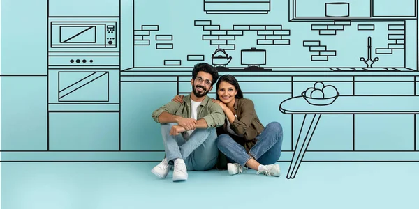 Real Estate Offer. Smiling Indian Young Couple Hugging Near Blue Wall With Illustration Of Modern Kitchen Room Interior With Drawn Furniture, Dreaming About Own House. Collage, Panorama