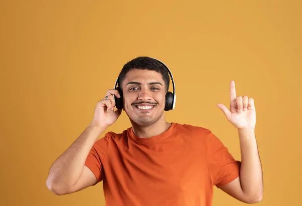 Радісний Бразильський Чоловік Слухає Музику Навушниках Посміхається Піднімаючи Палець Вгору — стокове фото