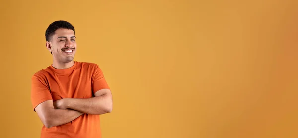 Positive Brazilian Man Orange Shirt Posing Crossed Arms Chest Winking — Stock Photo, Image