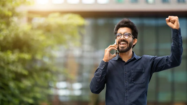 Ενθουσιασμένος Χαρούμενος Νεαρός Ινδός Επιχειρηματίας Έχει Τηλεφωνική Συνομιλία Και Σηκώνοντας — Φωτογραφία Αρχείου