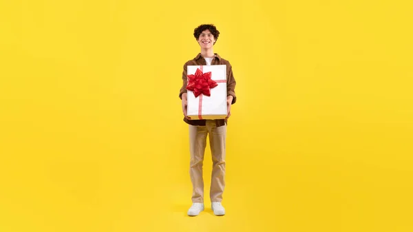 Szczęśliwy Młody Człowiek Luźnym Trzymając Duże Opakowane Pudełko Prezentami Zaleca — Zdjęcie stockowe