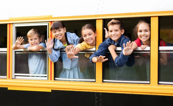 Группа Счастливых Детей Выглядывающих Окна Школьного Автобуса Машущих Улыбающихся Камеру — стоковое фото