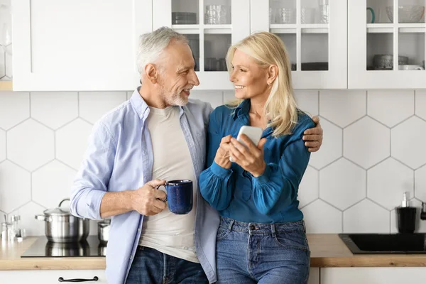 Smiling Mature Couple Relaxing Kitchen Smartphone Coffee Happy Senior Spouses — Stock Photo, Image