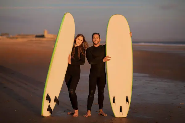 Piękna Para Surferów Dwoma Deskami Surfingowymi Pozującymi Plaży Zachodzie Słońca — Zdjęcie stockowe