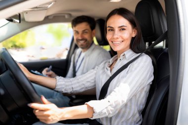 Yakışıklı erkek eğitmen, esmer kız öğrenciyi muayene ediyor, çizelgeye not alıyor, gülümseyen genç bir bayanın yanında oturuyor ve test sonuçlarını bekliyor, yan görüş, kopyalama alanı