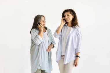 Telefonla arayan, gülümseyen beyaz, yaşlı ve yetişkin kadınlar, beyaz duvar arkasında boş vakitlerin tadını çıkarıyorlar. Ebeveynlerle iletişim, ilişkiler, anne ve kız, dedikodu, iyi haber, bağlantı