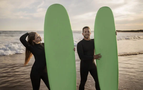 夏季活动 快乐的年轻夫妇在海滩上拥有冲浪板 快乐的千禧年男人和女人穿着湿衣一起冲浪 享受假期和水上运动 复制空间 — 图库照片