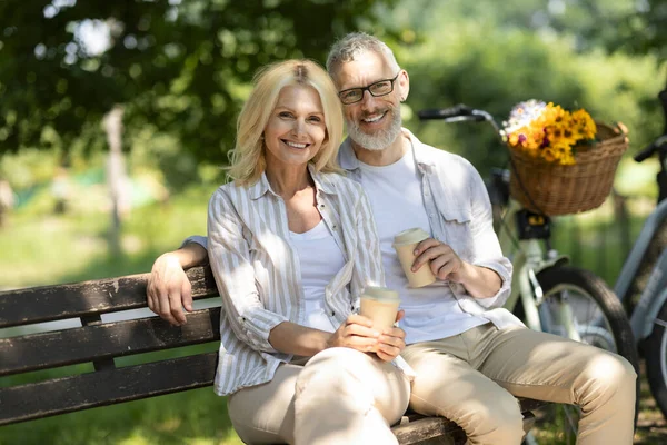 在公园的长椅上轻松享用外带咖啡的快乐伴侣 在高级配偶身边拥抱和欣赏相机 快乐的老人和享受户外休闲 自由自在的女人 — 图库照片
