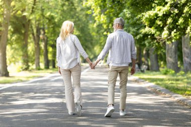 Açık hava randevusu. Romantik olgun bir çiftin parkta birlikte yürüdüğünü, son sınıf öğrencisiyle mutlu bir şekilde el ele tutuşup gülümsediklerini, birlikte vakit geçirdiklerini, uzayı kopyaladıklarını gösteren bir bakış açısı.