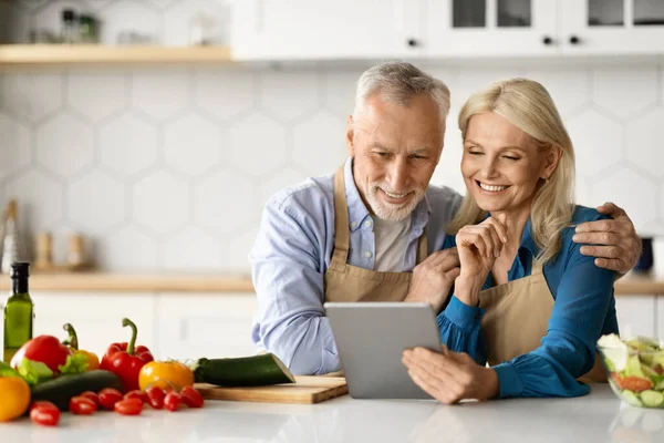 Lächelnde Ältere Ehepartner Verwenden Digitales Tablet Beim Gemeinsamen Kochen Von — Stockfoto