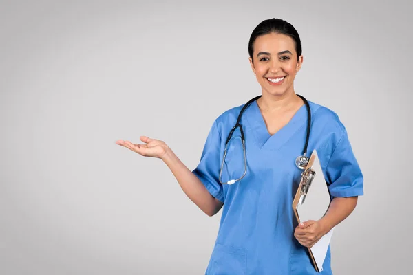 Весела Жінка Лікар Синьому Робочому Одязі Тримає Медичну Карту Вказуючи — стокове фото