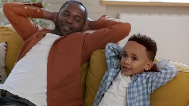 Weekendowy Relaks Szczęśliwy Beztroski Afrykański Ojciec Jego Synek Odpoczywający Domu — Wideo stockowe