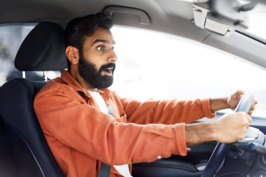 Tehlikeli Trafik Durumu 'ndan. Şok olmuş genç Hintli adam araba sürerken kaza yapma, direksiyon tutma, şokta yola bakma, yan görüş. Otomobil Seyahat Güvenliği Sayısı