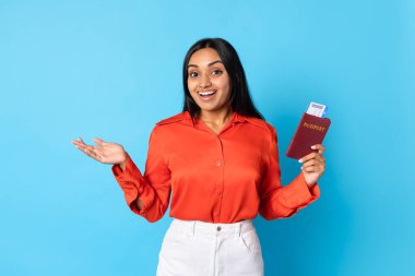 Seyahat Teklifi. Heyecanlı Orta Doğulu Turist Kadın Uçuş Kartı ve Pasaportu Mavi Arkaplanda Duruyor, Yeni Tatil Yolculuğundan Memnun, Ucuz Uçuş Biletleri İlan Ediyor