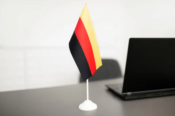 Flag Of Germany Standing Near Laptop Computer On Desk In Modern Office Interior, Advertisement Of Language Online Course Website, Modern University In Germany. Selective Focus