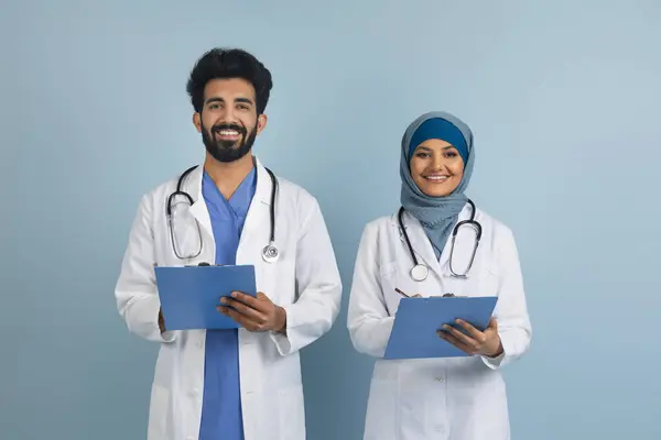 Retrato Macho Árabe Feliz Mulheres Médicos Uniforme Segurando Pranchetas Sorrindo — Fotografia de Stock