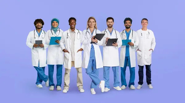 Beyaz Önlüklü Neşeli Uluslararası Doktorlar Mavi Stüdyo Arka Planında Izole — Stok fotoğraf