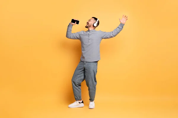 Portrait Carefree Asian Man Wireless Headphones Singing Smartphone Hand Cheerful — Stok Foto