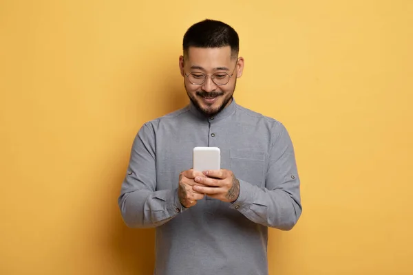 Lächelnder Junger Asiatischer Mann Mit Smartphone Den Händen Der Über — Stockfoto