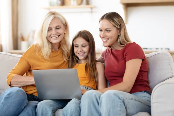 漂亮而快乐的高加索家庭母亲 十几岁前的女儿坐在家里的沙发上 上网看电影或卡通片 周末在一起度过 — 图库照片