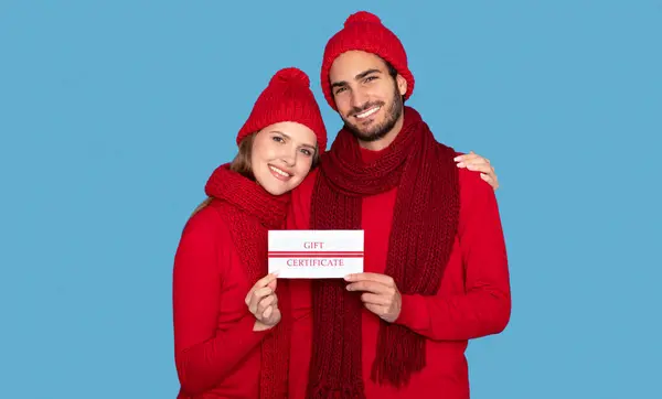 Glückliches Junges Paar Wintermützen Mit Gutschein Den Händen Und Lächelnd — Stockfoto