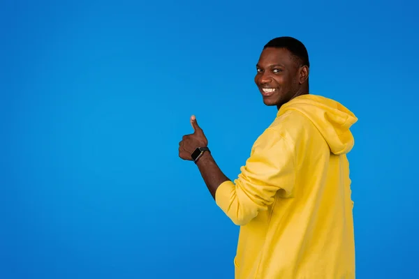 幸せな若いハンサムな黒人の男は ジェスチャーに親指を示し 青い背景 スタジオで孤立した余暇をお楽しみください 人間の感情 広告および提供 承認のよいニュース 肯定的なライフスタイル — ストック写真