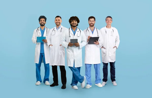 Beyaz Önlüklü Tabletli Yaşlı Olgun Uluslararası Erkek Doktorların Mavi Stüdyo — Stok fotoğraf
