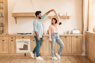 Romantik Hintli eşler mutfak içinde dans ediyorlar, sevgi dolu çiftler el ele tutuşuyorlar ve birbirlerine gülümsüyorlar, Hindu aşıklar birlikte vakit geçiriyorlar, tam boy, kopyalama alanı.