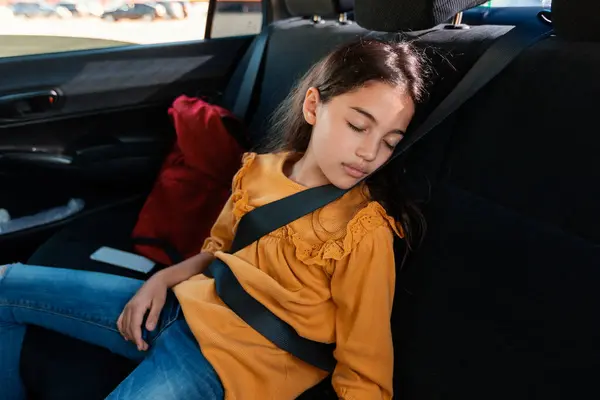 累了的小女孩在放学回家的路上开车睡觉 坐在后座上 系着安全带 家庭生活方式和汽车安全概念 — 图库照片