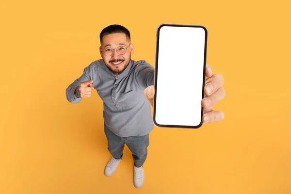 Koukni Tohle Usmívající Asijský Muž Ukazující Big Blank Smartphone Jeho — Stock fotografie