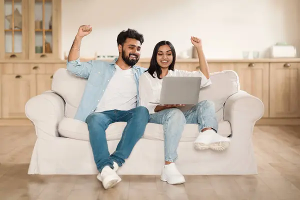 引き出し 宝くじ キャッシュバック 自宅でソファーに座っているラップトップを使用して楽しんだインドのカップル ジェスチャーと興奮 成功を祝う サーフィンインターネット コピースペース — ストック写真