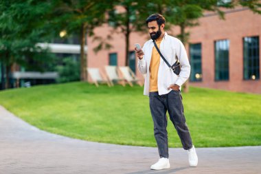 Akıllı telefon cihazıyla Arapça konuşan, internette gezinen ve akşamları şehir dışında dolaşırken mesajlaşan, iletişim için cep telefonuyla mobil uygulama kullanan bir adam. Boşluğu kopyala