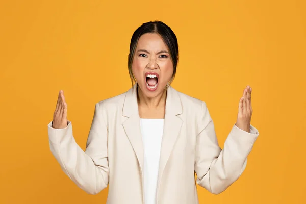 怒气冲冲的 悲喜交加的 穿着西服的年轻亚洲女人尖叫着 吓坏了 被黄色的工作室背景隔离了 人们的情绪 压力和过度工作 工作中的坏消息 — 图库照片