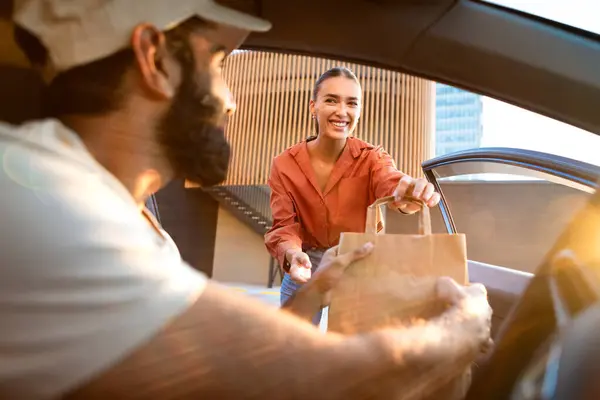 Express Delivery Service. Delivery Man Handing Parcel Cardboard Box To Customer Lady Through Opened Door In Automobile, Shallow Depth Shot, Focus On Happy Client Receiving Her Package