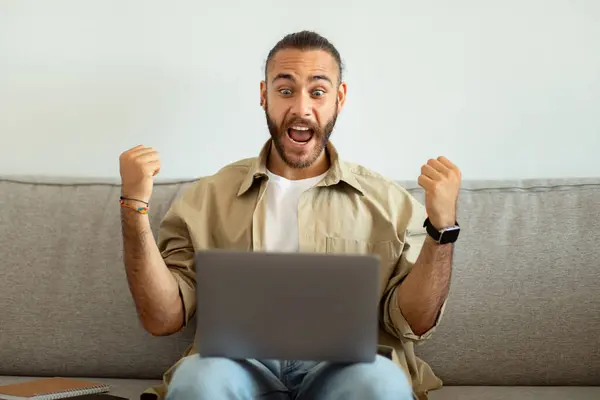 Супер Счастливый Человек Тысячелетия Использует Ноутбук Дома Празднует Успех Сжимая — стоковое фото