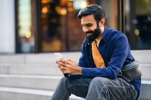 Şehirdeki basamaklarda otururken cep telefonu kullanan, akşamları şehir yürüyüşü sırasında dijital eğlencenin tadını çıkaran, mobil reklam için bedava alan