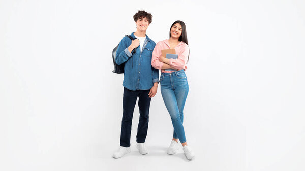 Educational Offer. Cheerful Young Students Duo Standing With Their Backpacks And Workbooks Over White Background. Full Length Studio Shot Of Boyfriend And Girlfriend Ready For College. Panorama