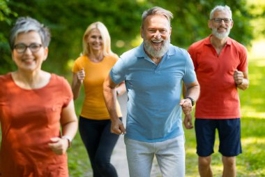 Aktif Emeklilik. Bir grup sportif son sınıf öğrencisi dışarıda koşuyor, Yeşil Park 'ta koşan mutlu yaşlı erkek ve kadınlar, spor eğitimlerinin ve sağlıklı yaşam tarzının keyfini çıkarıyorlar,