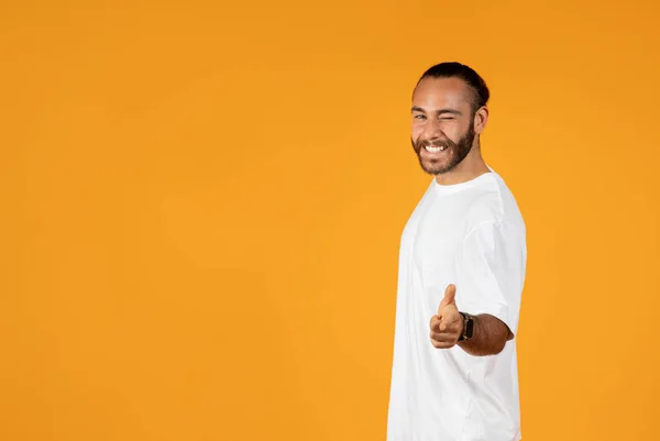 穿着白色T恤的快乐自信的欧洲裔成年人眨眼 在镜头前展示手指 在橙色工作室背景下被隔离 专业的建议 你的选择 转身和生活方式的动机 — 图库照片