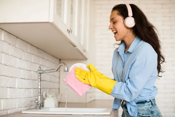 Joyful Woman Wearing Wireless Headphones Singing While Washing Dishes Kitchen — Stock Photo, Image