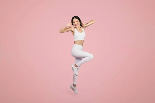 Aufgeregte Frau Sportbekleidung Und Drahtlosen Kopfhörern Die Über Rosa Hintergrund — Stockfoto