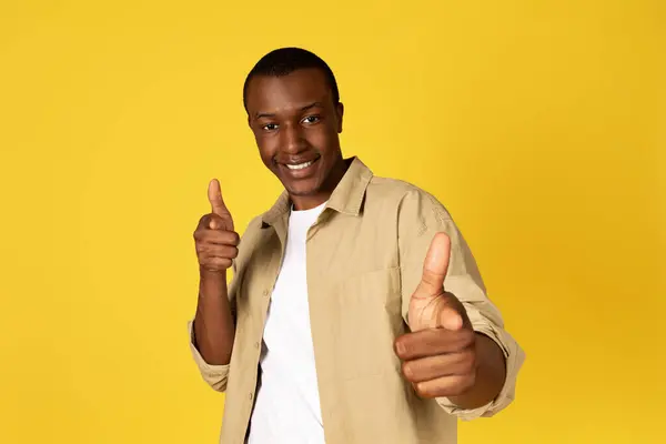 自信に満ちたミレニアム アフリカ系アメリカ人男性は 黄色いスタジオの背景に隔離されたカメラで指を示しています オファー モチベーション ライフスタイル あなたの選択 あなたのターン — ストック写真