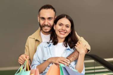 Bir sürü paketi olan mutlu beyaz bir çift yürüyüş, ilişkiler, kucaklaşmalar alışveriş merkezinde birlikte alışveriş yapmaktan keyif alır. Kapatın. İndirim sezonu, yaşam tarzı, reklam ve teklif, birlikte alım.