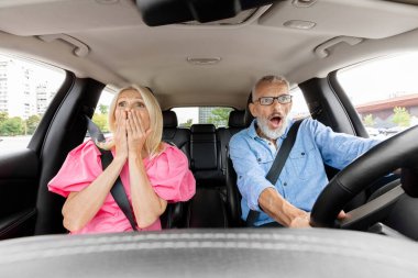 Araba sürerken araba kazası geçirme riskiyle karşı karşıya kalan, yüzü korkunç bir ifadeyle yola bakan Kafkasyalı yaşlı çift şok oldu. Otomatik gösterge panelinden görüntüle. Stresli trafik