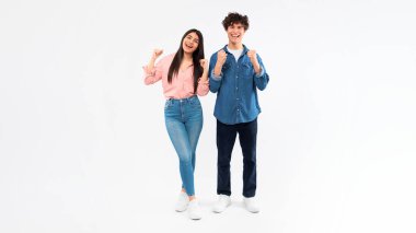 Vay canına, evet. Uzun boylu bir adam ve kız arkadaşı tezahürat yapıyor ve sıkılmış yumruklarını sallıyor, beyaz stüdyo arka planında kameraya gülümsüyor. Kazanan genç çift, panorama, kopyalama alanı