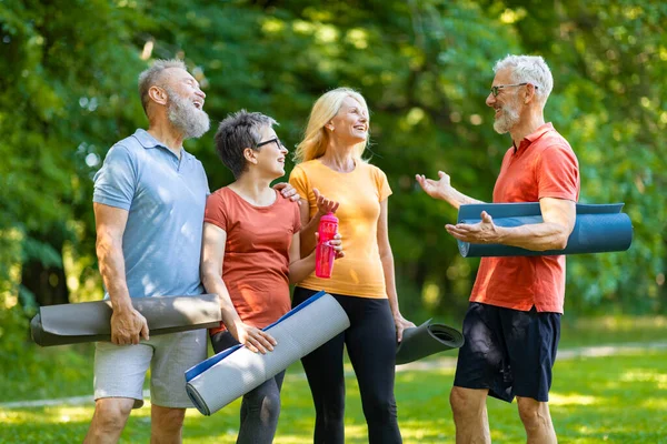 Group Of Active Senior People Having Fun While Training Together Outdoors, Happy Older Men And Women Chatting And Laughing, Relaxing After Outside Workout, Enjoying Sporty Lifestyle