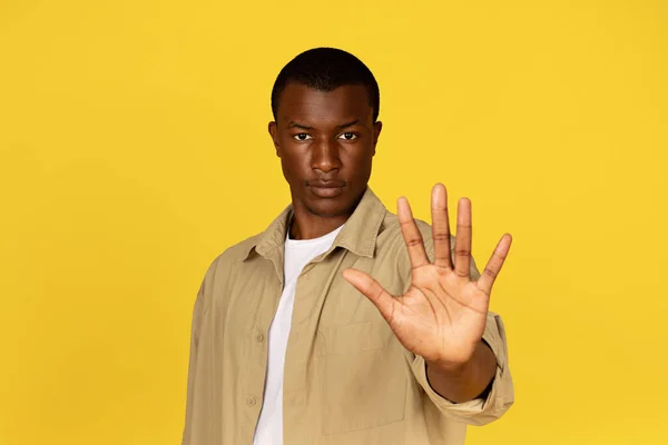 심각한 엄격한 밀레니엄 아프리카계 미국인 남자는 노란색 스튜디오 배경에 손으로 — 스톡 사진