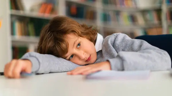 Disengaged Schoolboy Lying His Desk Primary School Classroom Seemingly Boring — Stock Photo, Image