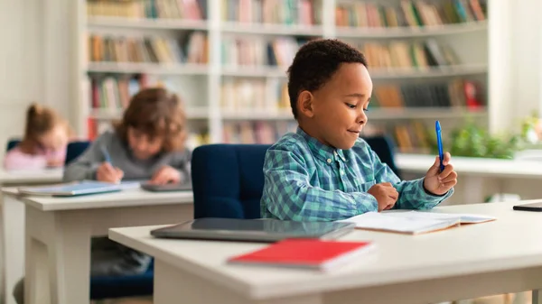 Black Schoolboy Sitting His Desk Observing Attentively Lesson Primary Classroom — Stock Photo, Image