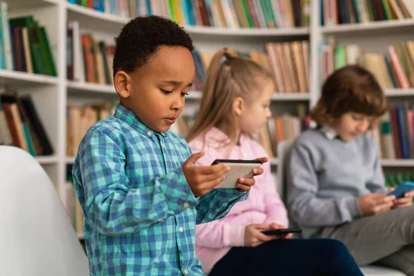 Vielfältige Schulkinder Grundschulbereich Voll Vertieft Fröhlich Mit Ihren Handys Spielend — Stockfoto